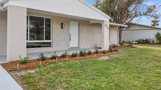 doorway to property with cooling unit and a yard