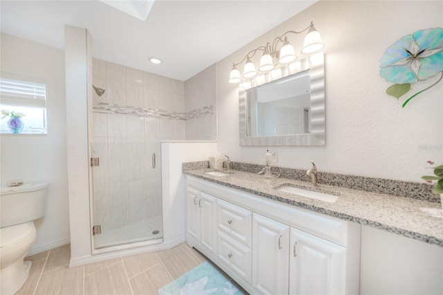 bathroom with tile patterned floors, a shower with door, vanity, and toilet