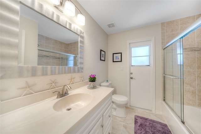 full bathroom with vanity, bath / shower combo with glass door, and toilet