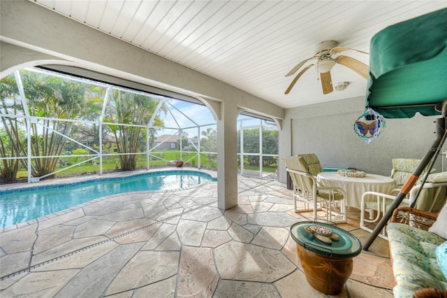 view of swimming pool with a lanai, ceiling fan, and a patio area