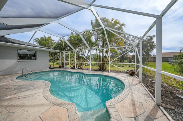 view of pool with glass enclosure and a patio area