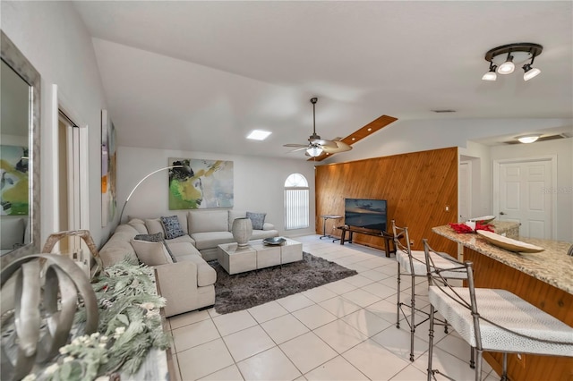 living room featuring ceiling fan, light tile patterned flooring, and vaulted ceiling