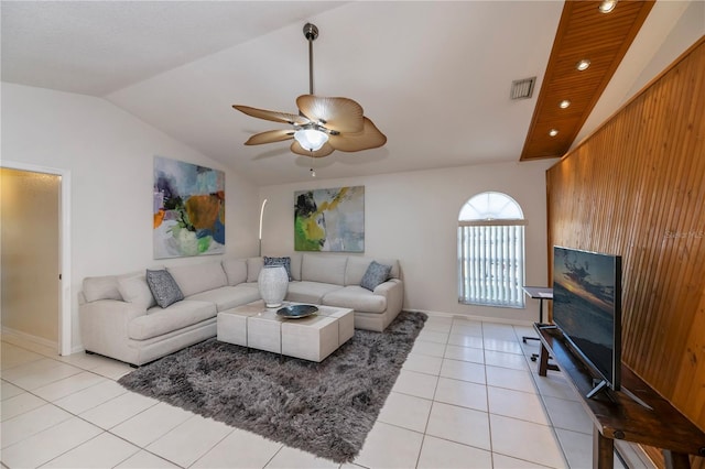 living room featuring light tile patterned floors, ceiling fan, lofted ceiling, and wood walls