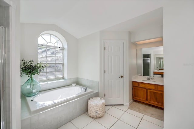 bathroom featuring tile patterned floors, tiled bath, vanity, and lofted ceiling