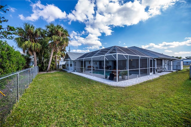 rear view of property with a fenced in pool, a lanai, and a lawn