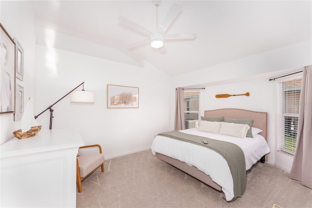 bedroom with ceiling fan, light colored carpet, multiple windows, and vaulted ceiling