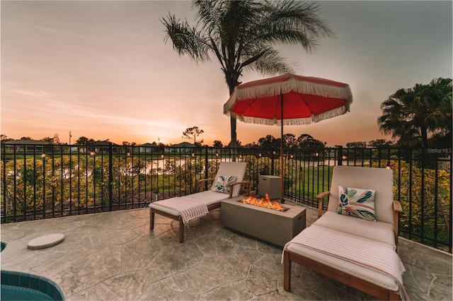 patio terrace at dusk featuring a fire pit