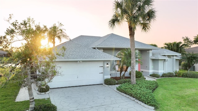 view of front facade with a yard and a garage