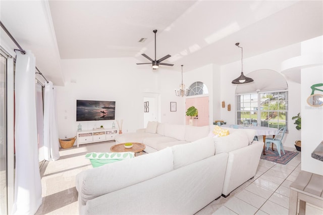 tiled living room with ceiling fan and high vaulted ceiling