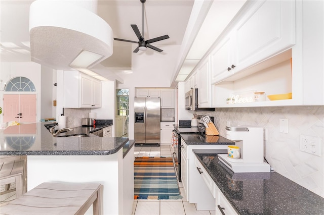 kitchen with sink, stainless steel appliances, white cabinets, a breakfast bar area, and light tile patterned flooring