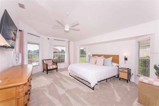 bedroom with ceiling fan, light colored carpet, and vaulted ceiling