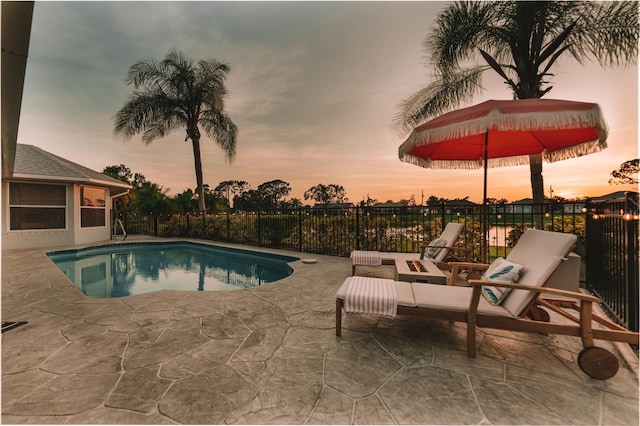 pool at dusk with a patio area