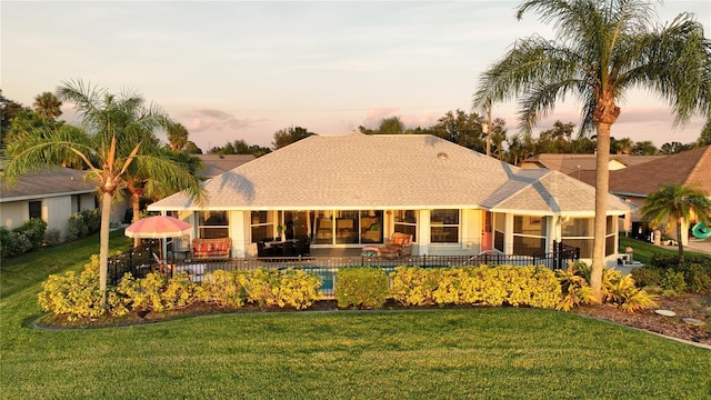 view of front of property with a yard and a swimming pool