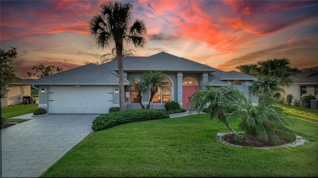 view of front of house with a garage and a yard