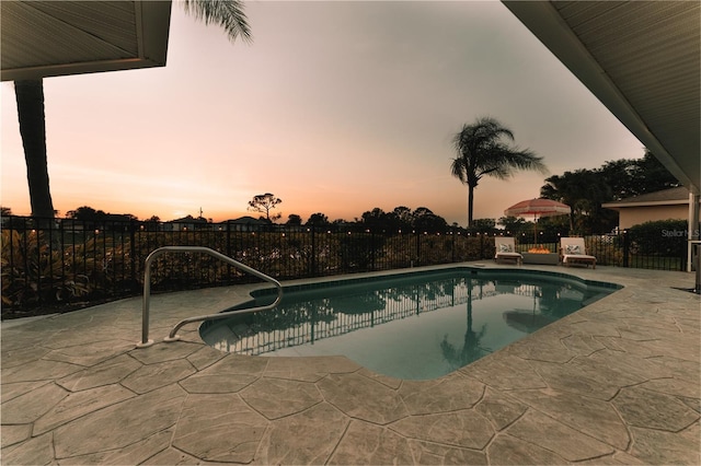 pool at dusk featuring a patio area