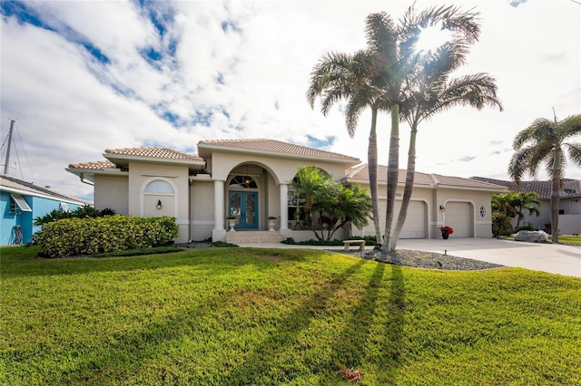 mediterranean / spanish home featuring a garage and a front yard