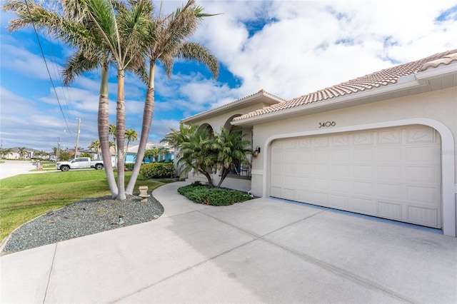 mediterranean / spanish-style house featuring a front lawn and a garage