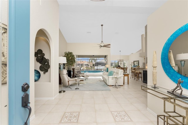 tiled living room with ceiling fan and high vaulted ceiling