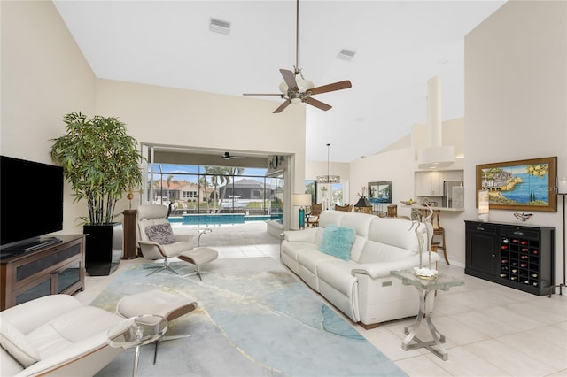 tiled living room with ceiling fan and high vaulted ceiling