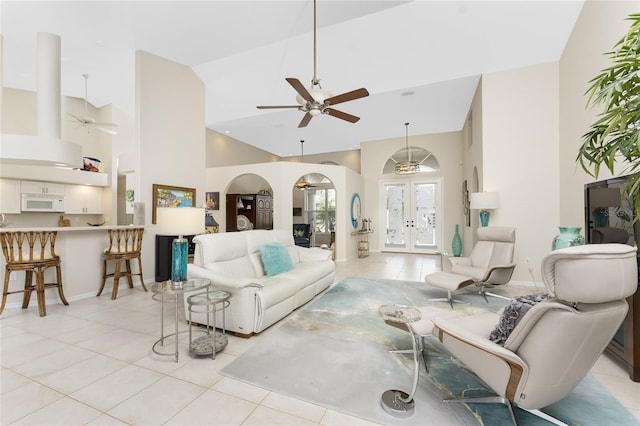 tiled living room with ceiling fan, a high ceiling, and french doors