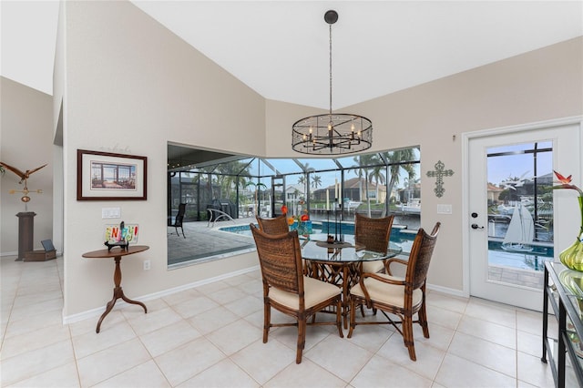 dining area with light tile patterned floors, high vaulted ceiling, and a chandelier