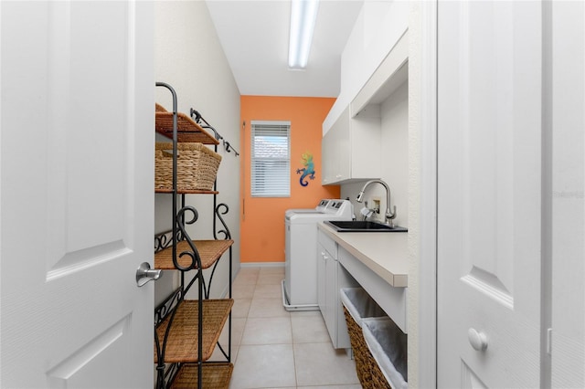 clothes washing area featuring separate washer and dryer, sink, light tile patterned flooring, and cabinets