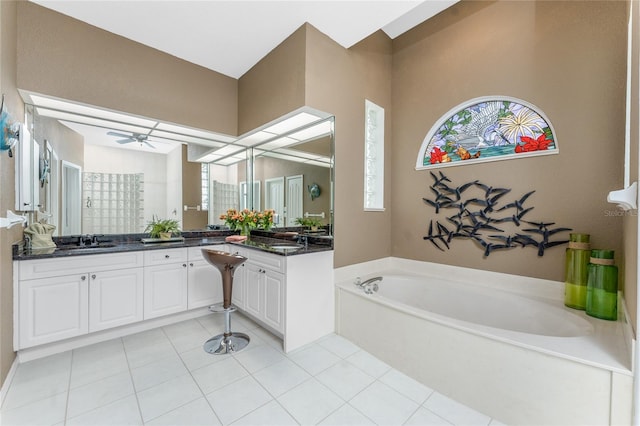 bathroom with tile patterned floors, vanity, and a tub to relax in