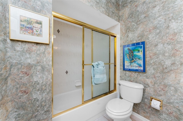 bathroom featuring combined bath / shower with glass door and toilet