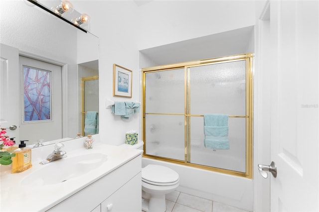 full bathroom with tile patterned flooring, vanity, bath / shower combo with glass door, and toilet