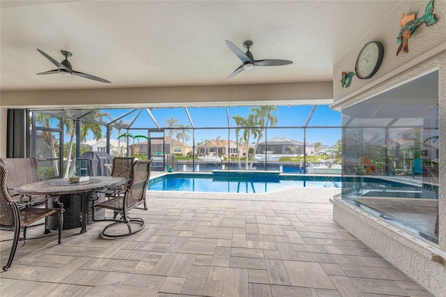 view of swimming pool with a patio area, ceiling fan, and glass enclosure