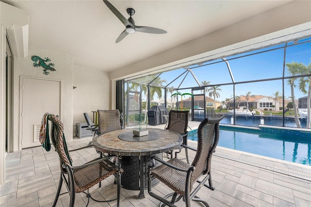 view of patio / terrace with ceiling fan, a water view, and glass enclosure