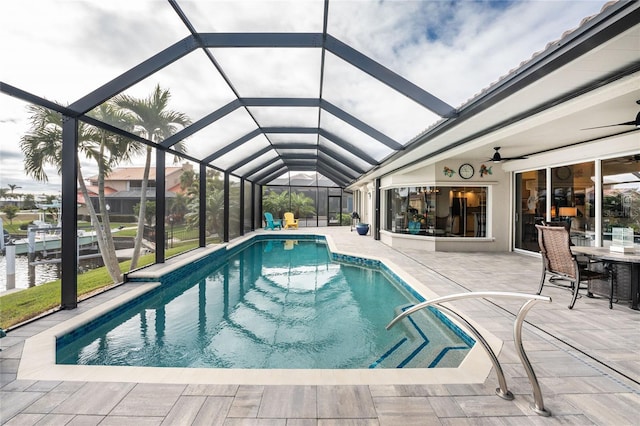 view of pool with a patio, a water view, and a lanai