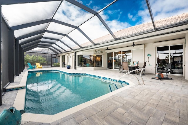 view of swimming pool with a patio, glass enclosure, and ceiling fan