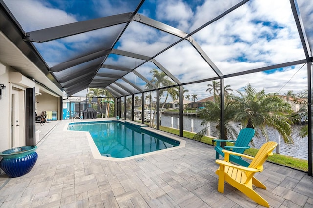 view of pool featuring glass enclosure, a water view, and a patio