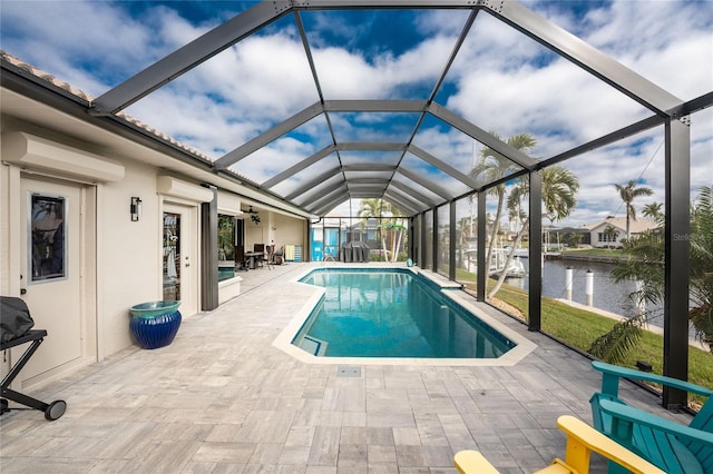 view of swimming pool with a wall unit AC, ceiling fan, a water view, glass enclosure, and a patio