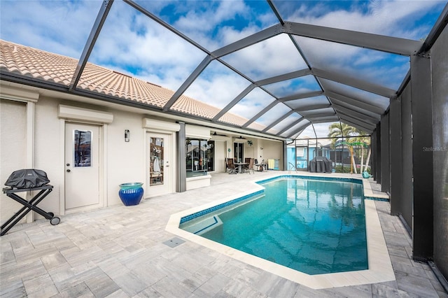 view of pool featuring a lanai, a patio area, ceiling fan, and grilling area