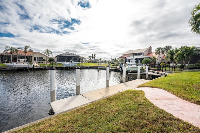 dock area with a lawn and a water view