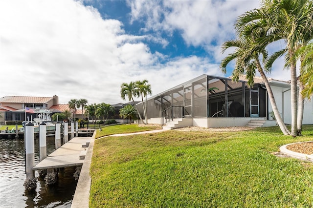 view of yard with glass enclosure, a dock, and a water view