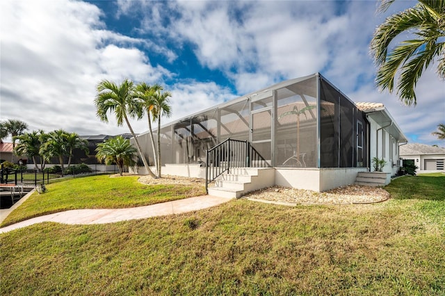 back of property with a lawn and a lanai