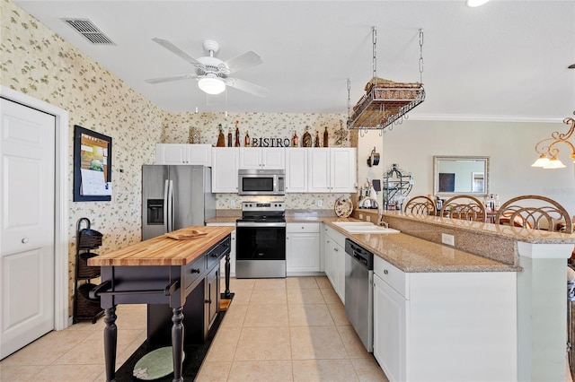 kitchen featuring white cabinetry, appliances with stainless steel finishes, sink, and light tile patterned floors