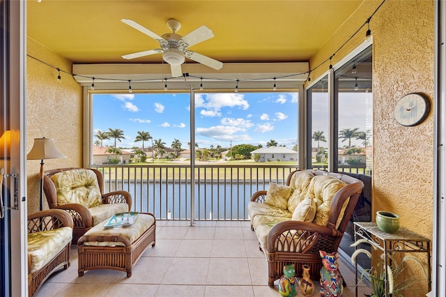 sunroom / solarium featuring a water view, ceiling fan, and plenty of natural light