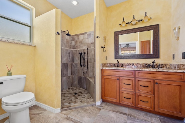 bathroom with vanity, toilet, and a tile shower