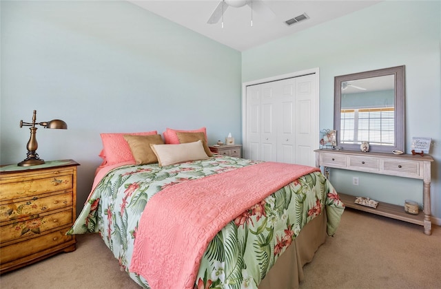 bedroom featuring light colored carpet, a closet, and ceiling fan