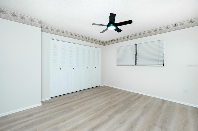 unfurnished bedroom with ceiling fan, a closet, and light hardwood / wood-style flooring