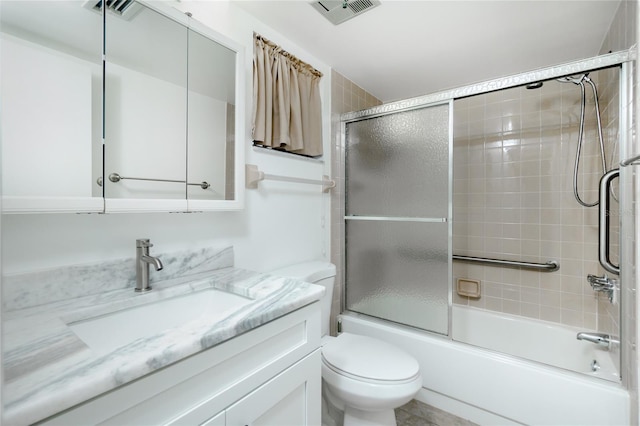 full bathroom featuring vanity, combined bath / shower with glass door, and toilet