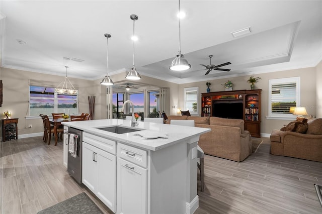 kitchen featuring pendant lighting, a kitchen island with sink, white cabinets, sink, and ceiling fan