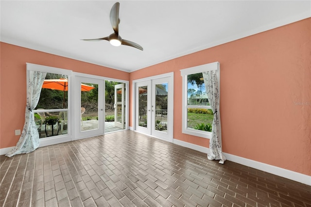 empty room with ceiling fan and french doors