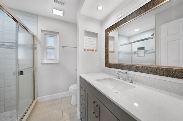 bathroom with tile patterned floors, vanity, a shower with shower door, and toilet