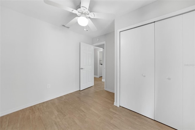 unfurnished bedroom featuring a closet, light hardwood / wood-style flooring, and ceiling fan