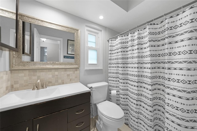 bathroom featuring backsplash, curtained shower, vanity, and toilet